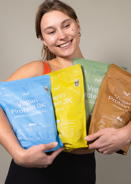 Une femme porte 4 paquets de nu3 Vegan Protein 3K.