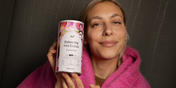 Femme heureuse avec une boîte de nu3 Balancing Hot Cocoa