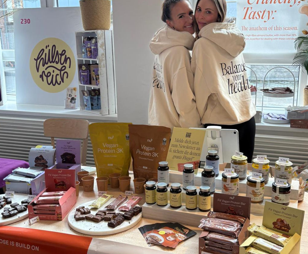Stand nu3 avec des produits et 2 femmes qui sourient